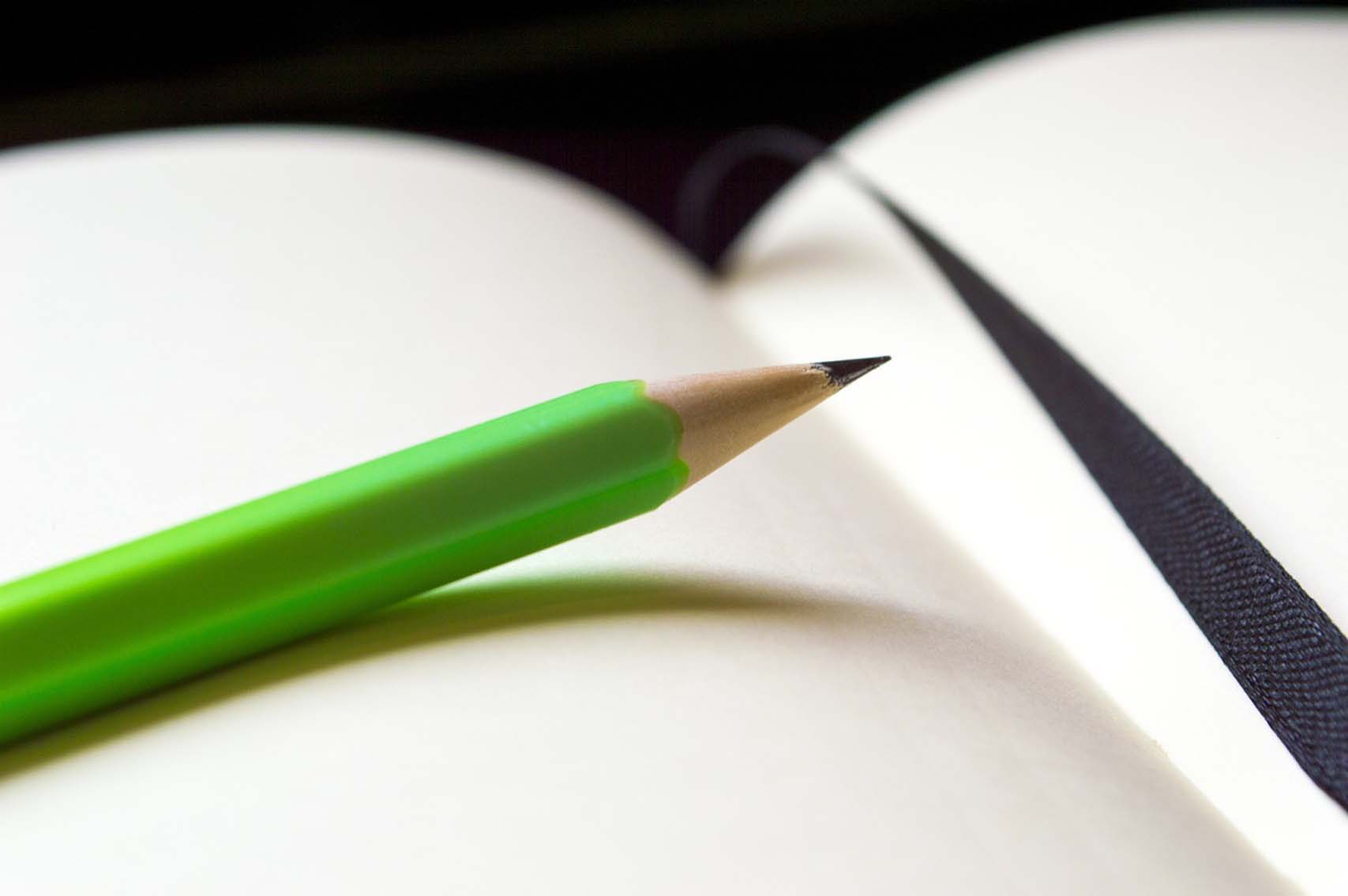 Un lápiz apoyado sobre un cuaderno. 